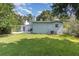 Grassy backyard with mature trees providing ample shade and a patio, perfect for outdoor activities at 1219 Oakley St, Orlando, FL 32806