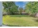 Large, green backyard enclosed by a wooden fence and mature trees for maximum privacy at 1219 Oakley St, Orlando, FL 32806