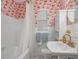 Charming bathroom featuring pink wallpaper with whimsical designs, a classic vanity, and vintage style at 1219 Oakley St, Orlando, FL 32806