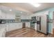 View of open floor plan kitchen with stainless steel appliances and a blue backsplash at 1219 Oakley St, Orlando, FL 32806
