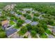 An aerial view of homes in a neighborhood with manicured lawns, mature trees, and a tranquil pond in the background at 127 Heatherbrooke Cir, Oviedo, FL 32765