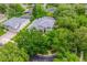 An aerial view of a gray two-story house with a blue door, lush landscaping, and a circular driveway on a cul-de-sac at 127 Heatherbrooke Cir, Oviedo, FL 32765