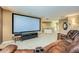 Basement area features projector screen, leather reclining sofa, and bar area at 127 Heatherbrooke Cir, Oviedo, FL 32765