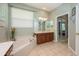 Bathroom area features a drop in tub, double sinks, and access to main bedroom at 127 Heatherbrooke Cir, Oviedo, FL 32765