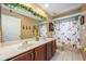Bathroom with a double sink, a large mirror and a shower with a dog-themed curtain at 127 Heatherbrooke Cir, Oviedo, FL 32765