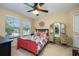 Bright bedroom with large window, ceiling fan, decorative vanity, and colorful bedding at 127 Heatherbrooke Cir, Oviedo, FL 32765