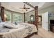 Elegant bedroom boasts a carved four-poster bed, tray ceiling, and large windows providing ample natural light at 127 Heatherbrooke Cir, Oviedo, FL 32765