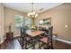 Elegant dining room features a wooden table, a decorative chandelier, and ample natural light at 127 Heatherbrooke Cir, Oviedo, FL 32765