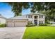 Charming two-story home boasts lush landscaping, a three-car garage, and a welcoming blue front door at 127 Heatherbrooke Cir, Oviedo, FL 32765