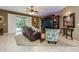 Cozy living room showcasing tile floors, a decorative ceiling fan, and convenient access to the outdoor pool area at 127 Heatherbrooke Cir, Oviedo, FL 32765