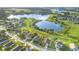 An aerial view of a neighborhood with a community lake in the distance and a community park at 1315 Vista Del Lago Blvd, Dundee, FL 33838