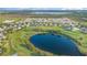 An aerial view of a residential community situated around a pond and surrounded by green fields at 1315 Vista Del Lago Blvd, Dundee, FL 33838