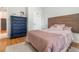 Bedroom boasting a unique blue dresser, wooden headboard, with shiny pink and neutral-colored bedding at 1315 Vista Del Lago Blvd, Dundee, FL 33838