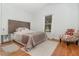 Well-lit bedroom featuring neutral tones, a wooden headboard, and a cozy chair with a floral pattern at 1315 Vista Del Lago Blvd, Dundee, FL 33838