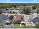 A sunny aerial view of a well-maintained neighborhood, featuring homes with solar panels and lush landscaping at 144 Bridgeton St, Davenport, FL 33896