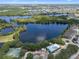 An aerial of a lakefront community featuring tennis courts, a pool, and condo buildings at 144 Bridgeton St, Davenport, FL 33896