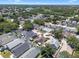Wide aerial view of a residential neighborhood featuring lush tree coverage and diverse single-Gathering homes and a pond at 144 Bridgeton St, Davenport, FL 33896
