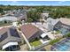 Aerial view showing a house with solar panels in a neighborhood with mature trees at 144 Bridgeton St, Davenport, FL 33896