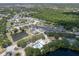 Aerial view of a community featuring several ponds, a pool, tennis courts and lots of trees at 144 Bridgeton St, Davenport, FL 33896