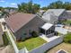 Well-maintained fenced backyard with a screened-in patio, lawn, and landscaped garden beds at 144 Bridgeton St, Davenport, FL 33896