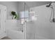 Bright bathroom with tiled shower, glass door, and relaxing tub at 144 Bridgeton St, Davenport, FL 33896
