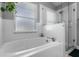 Clean, white tub and shower combination with tiled walls and glass door at 144 Bridgeton St, Davenport, FL 33896