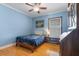 Cozy blue bedroom with a ceiling fan, hardwood floors, and lots of natural light at 144 Bridgeton St, Davenport, FL 33896