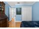 Cozy blue bedroom with hardwood floors, closet, and vintage cabinet at 144 Bridgeton St, Davenport, FL 33896
