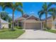 Inviting single-story home featuring lush landscaping, a two-car garage, and a well-maintained lawn at 144 Bridgeton St, Davenport, FL 33896