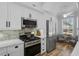 Modern kitchen with stainless steel appliances, white cabinets, and tile backsplash offers updated look at 144 Bridgeton St, Davenport, FL 33896