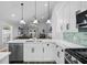 Modern kitchen island with stainless steel appliances and white cabinets overlooks the living room at 144 Bridgeton St, Davenport, FL 33896