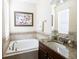 Bathroom featuring tub with tile surround and a granite topped vanity at 14845 Speer Lake Dr, Winter Garden, FL 34787