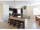 Open-concept kitchen featuring a breakfast bar with dark wood stools, tile flooring and granite counters at 14845 Speer Lake Dr, Winter Garden, FL 34787
