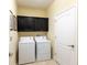 Laundry room with a washer, dryer, and dark cabinets for storage at 14845 Speer Lake Dr, Winter Garden, FL 34787