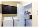 Laundry room with a washer, dryer, and storage cabinets that leads to the garage at 14845 Speer Lake Dr, Winter Garden, FL 34787