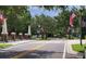 A welcoming neighborhood entrance featuring American flags, trees, and brick pillars at 14845 Speer Lake Dr, Winter Garden, FL 34787