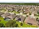 Stunning aerial view showcasing a neighborhood near a lake, featuring houses with solar panels and screened-in pools at 1507 Alligator St, St Cloud, FL 34771