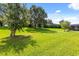 Large, grassy backyard featuring mature trees, offering a serene and private outdoor space at 1507 Alligator St, St Cloud, FL 34771