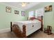 A bedroom featuring a wooden frame bed, fan, and natural light from the window at 1507 Alligator St, St Cloud, FL 34771