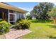 Cozy screened patio with brick surface and lush landscaping, perfect for outdoor relaxation at 1507 Alligator St, St Cloud, FL 34771