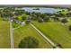 Aerial view of a lakefront community with lush green grass, mature trees, and winding driveways at 16610 County Line Rd, Umatilla, FL 32784