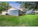 Large backyard featuring vibrant plants and a view of the home's exterior, with a shed in the background at 16610 County Line Rd, Umatilla, FL 32784