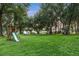 Expansive backyard view with mature trees and a wooden playset, showcasing outdoor recreational space at 16610 County Line Rd, Umatilla, FL 32784