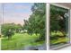 Large window shows the verdant green lawn and mature trees in the backyard beyond at 16610 County Line Rd, Umatilla, FL 32784
