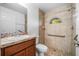 Bathroom with tiled shower featuring a grab bar, sink with a wood cabinet, and a window at 16610 County Line Rd, Umatilla, FL 32784