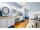 Elegant bathroom featuring double vanity sinks, granite countertop, and a soaking tub at 16610 County Line Rd, Umatilla, FL 32784