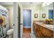 Bathroom featuring dual sinks, rustic wood cabinets, and a sunflower shower curtain at 16610 County Line Rd, Umatilla, FL 32784