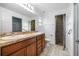 Bathroom featuring dual sinks, wood cabinets, a shower, and tile floors at 16610 County Line Rd, Umatilla, FL 32784