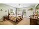 Bedroom featuring two windows, a floral bed set, and a vintage wooden dresser and nightstand at 16610 County Line Rd, Umatilla, FL 32784