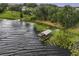 A covered boat dock with a lift sits on a calm lake surrounded by lily pads and green grass at 16610 County Line Rd, Umatilla, FL 32784